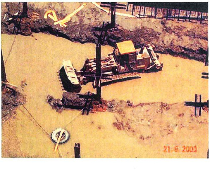 Maquinaria de obra trabajando en una excavación con presencia de agua